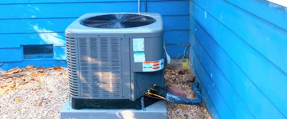 AC Unit next to an exterior wall. The wall is blue.