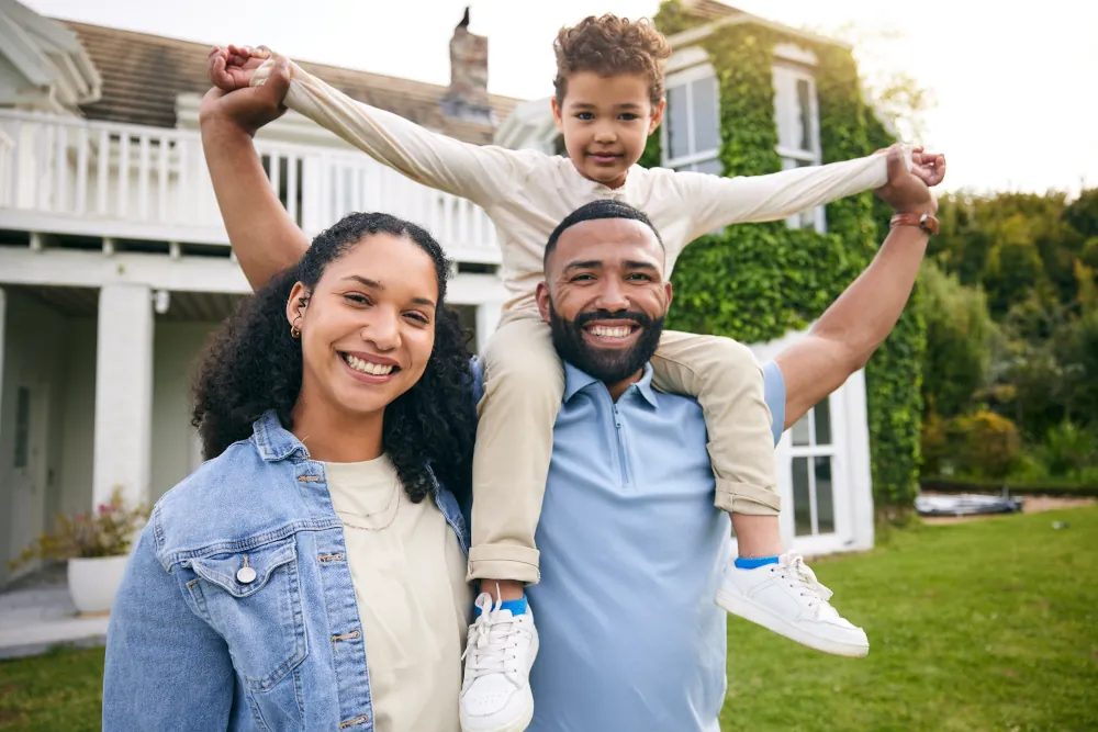 Family standing in front of their home on a sunny day.