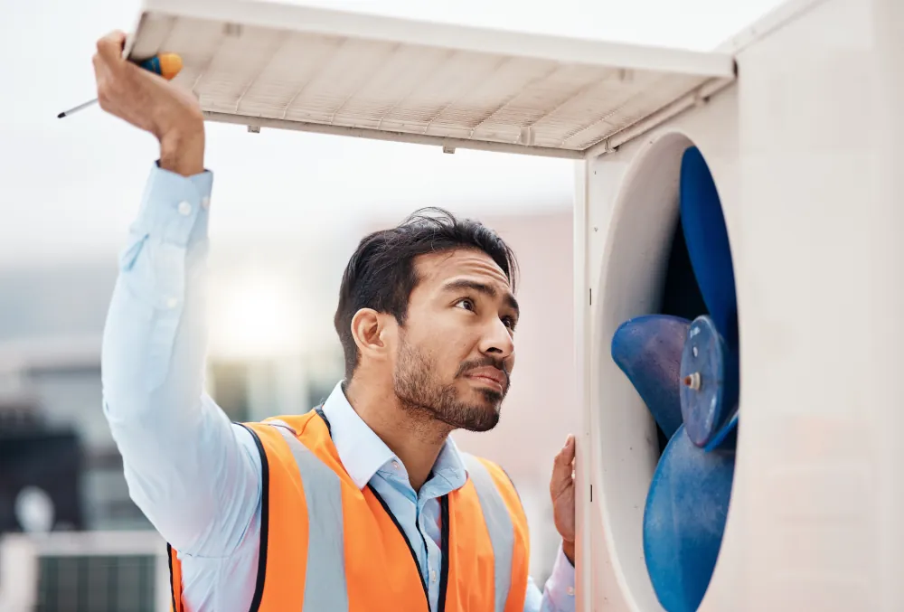 HVAC technician inspecting an external HVAC unit